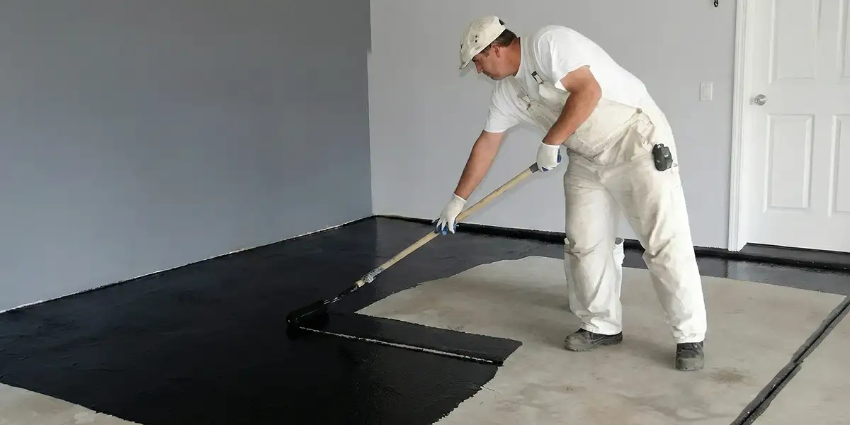 basement waterproofing professional applying waterproof coating to protect a basement floor in Aurora, CO